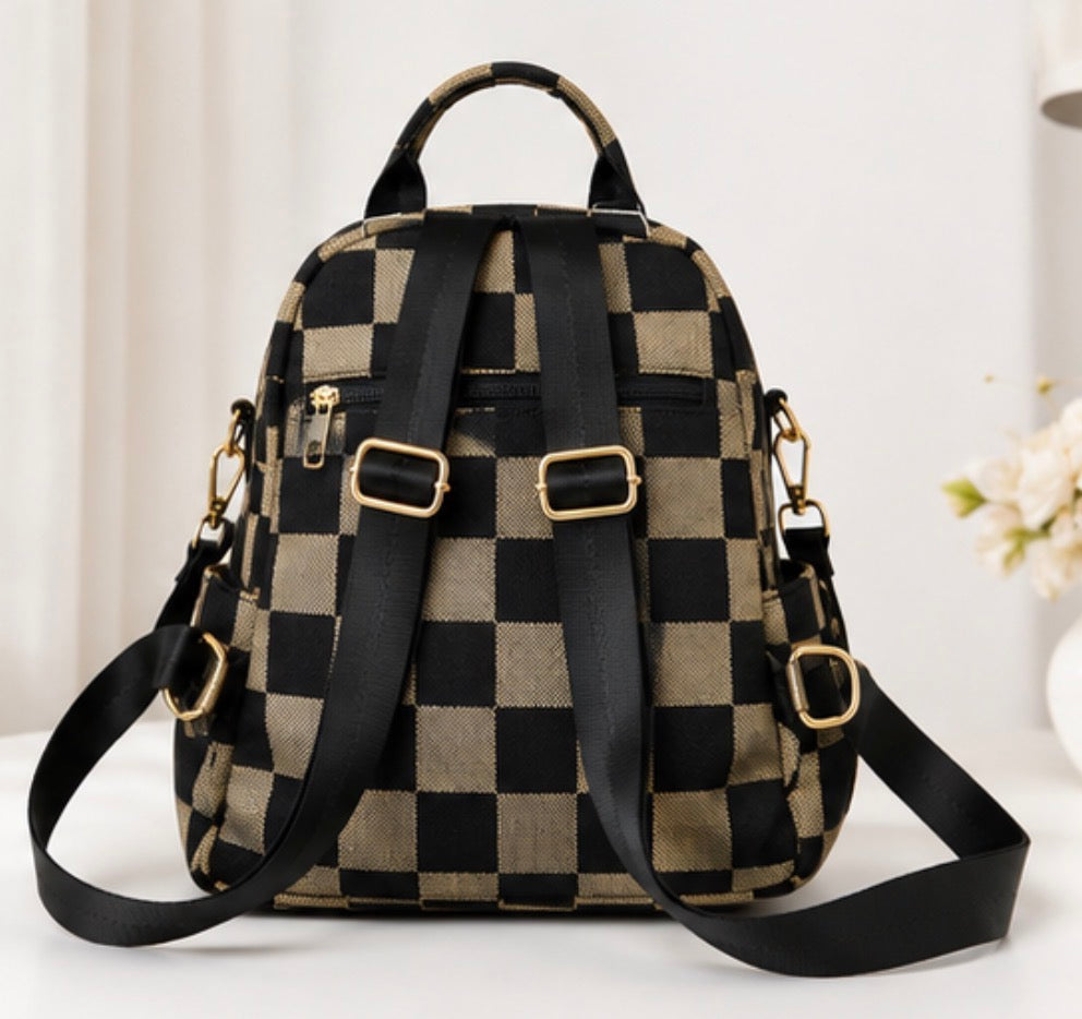 Black and tan checkerboard convertible backpack with adjustable straps and detachable crossbody shoulder strap.