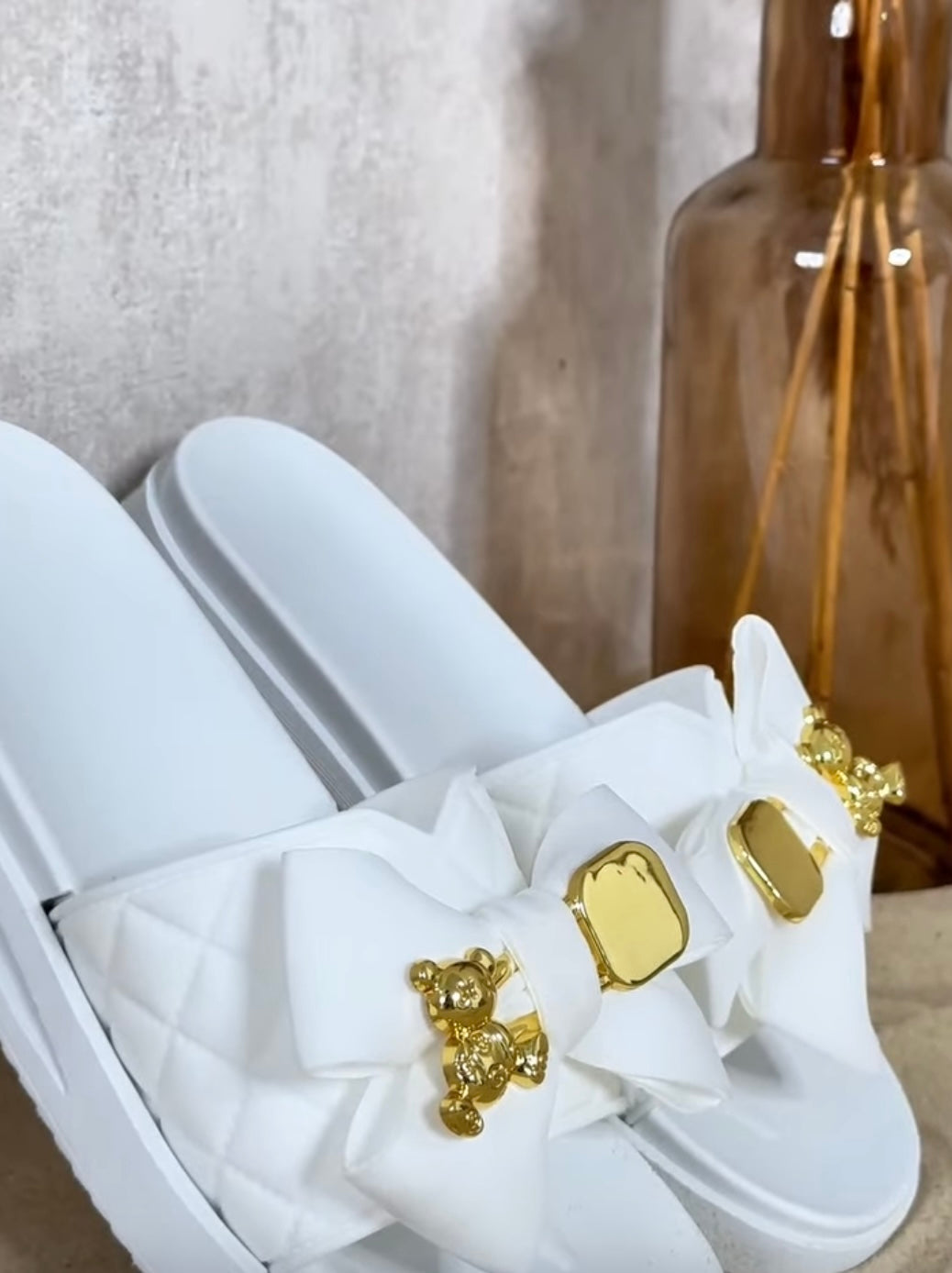 White sandals with gold teddy bear embellishments