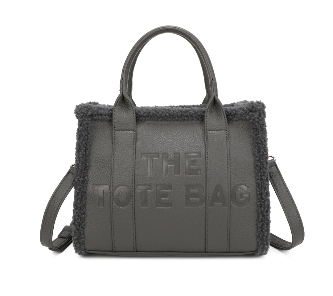 Tote bags with fuzzy edge trim, embossed with ‘The Tote Bag’ on the front in grey