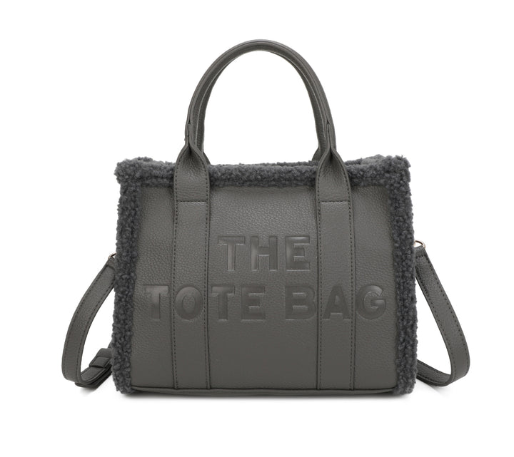 Tote bags with fuzzy edge trim, embossed with ‘The Tote Bag’ on the front in grey