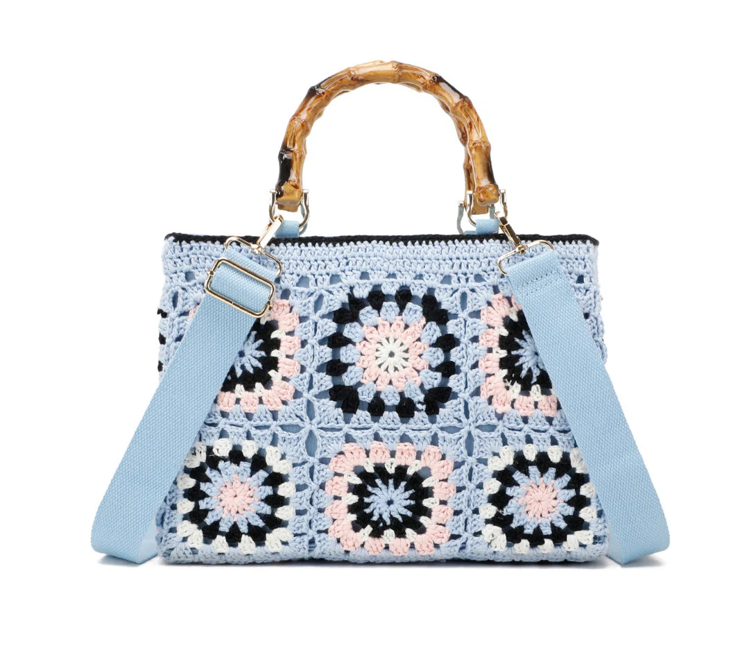 Light blue crochet grab bags with bamboo handles and gold tone metal hardware.