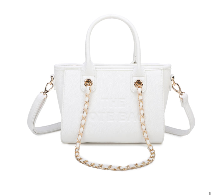 A white tote bag with a chain handle, featuring a front zipper pocket and gold tone metal hardware. The &