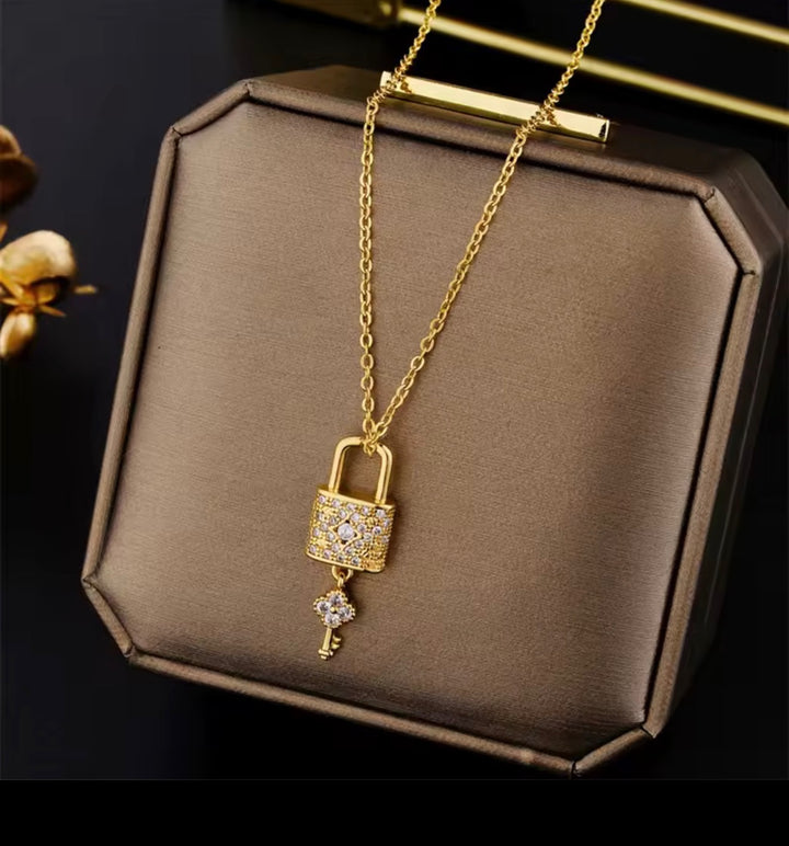Gold lock and key pendant necklace with crystal detail on a fine gold chain