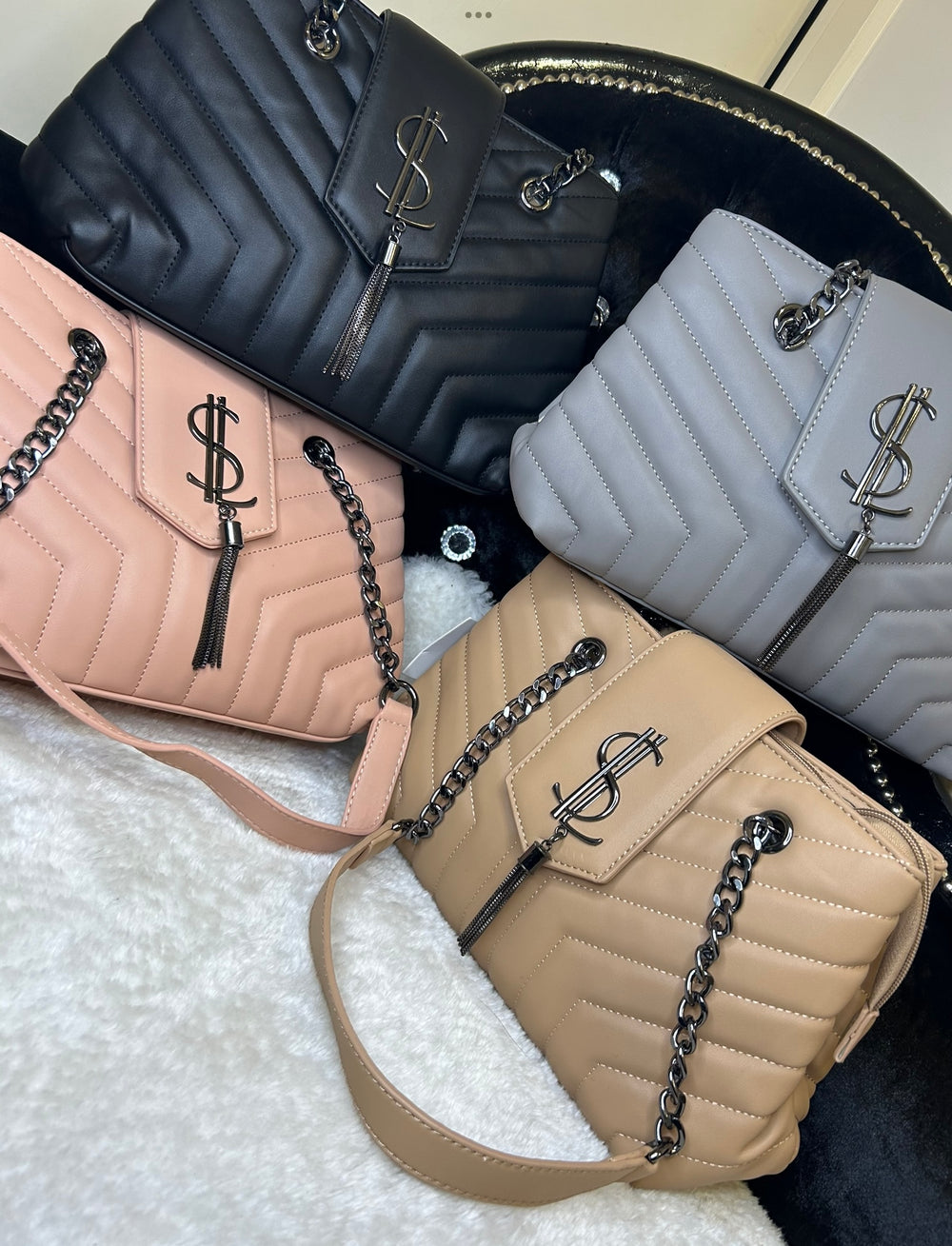 A collection of quilted medium sized handbags with chain detail in black, grey, pink, and beige colours.