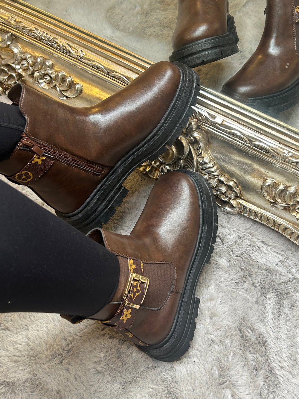 Chunky brown ankle boots with gold buckle detail, elastic side panels and thick black soles