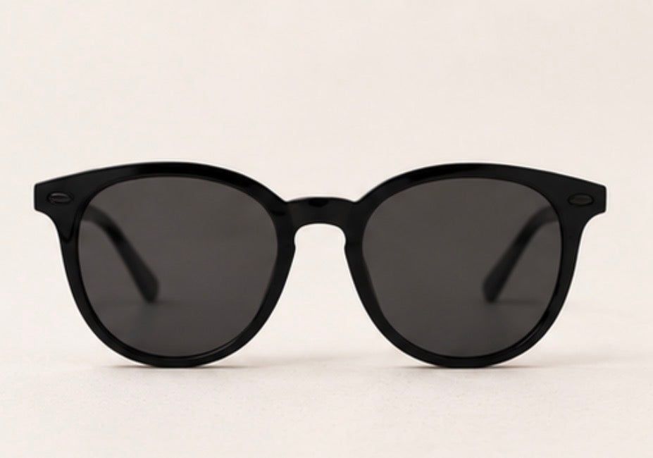 Black round frame sunglasses with dark tinted lenses and black hardware detail
