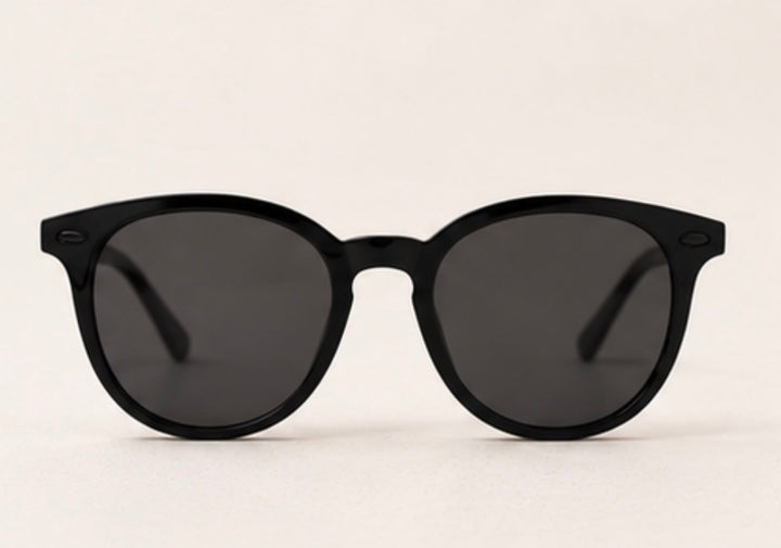 Black round frame sunglasses with dark tinted lenses and black hardware detail