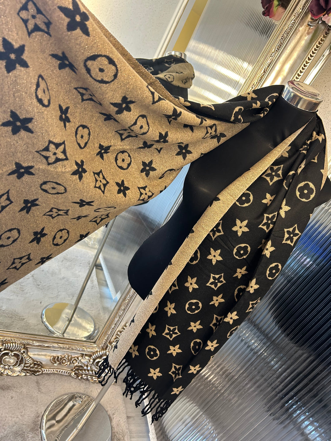 A black scarf with sparkly metallic thread floral patterns, draped elegantly with a focus on the sparkly details.