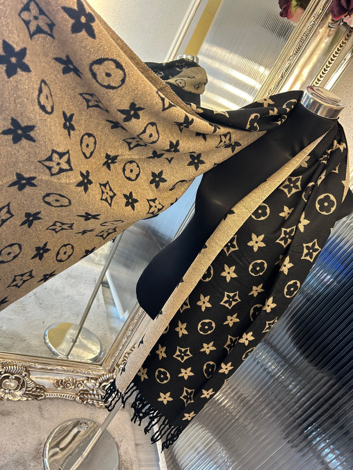 A black scarf with sparkly metallic thread floral patterns, draped elegantly with a focus on the sparkly details.