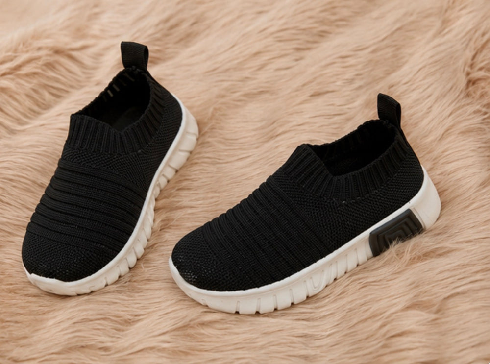 Kids slip-on trainers in plain black design with lightweight flexible soles.