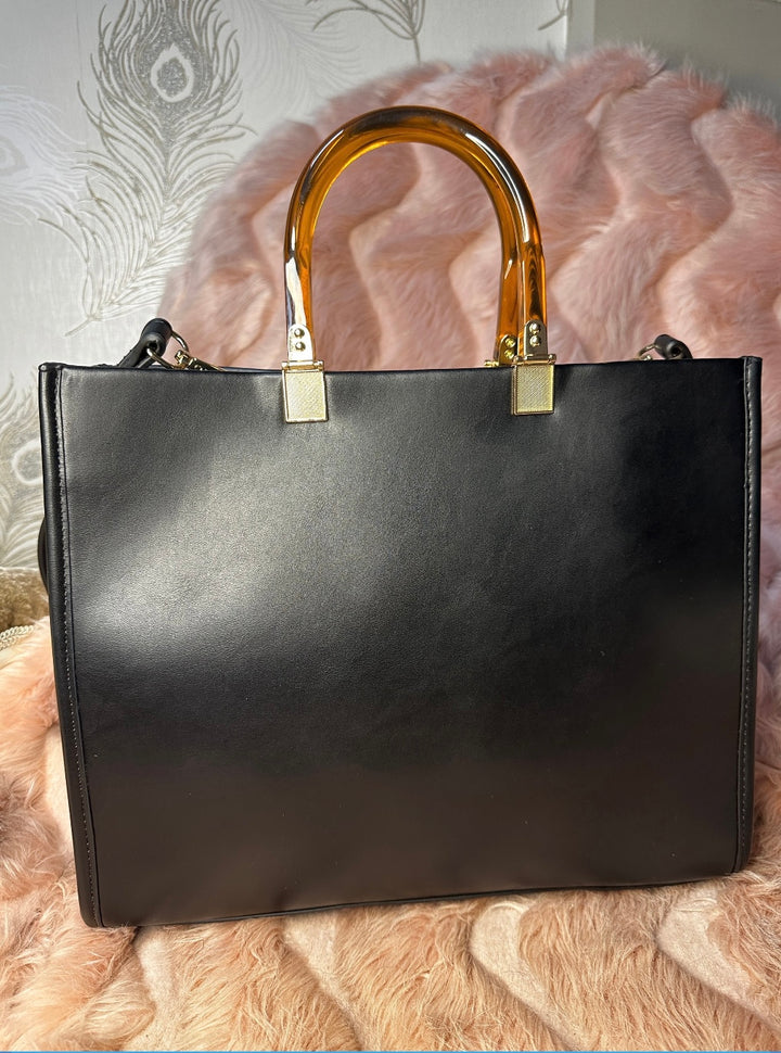 back of black faux leather tote bag with the cbs logo on the front