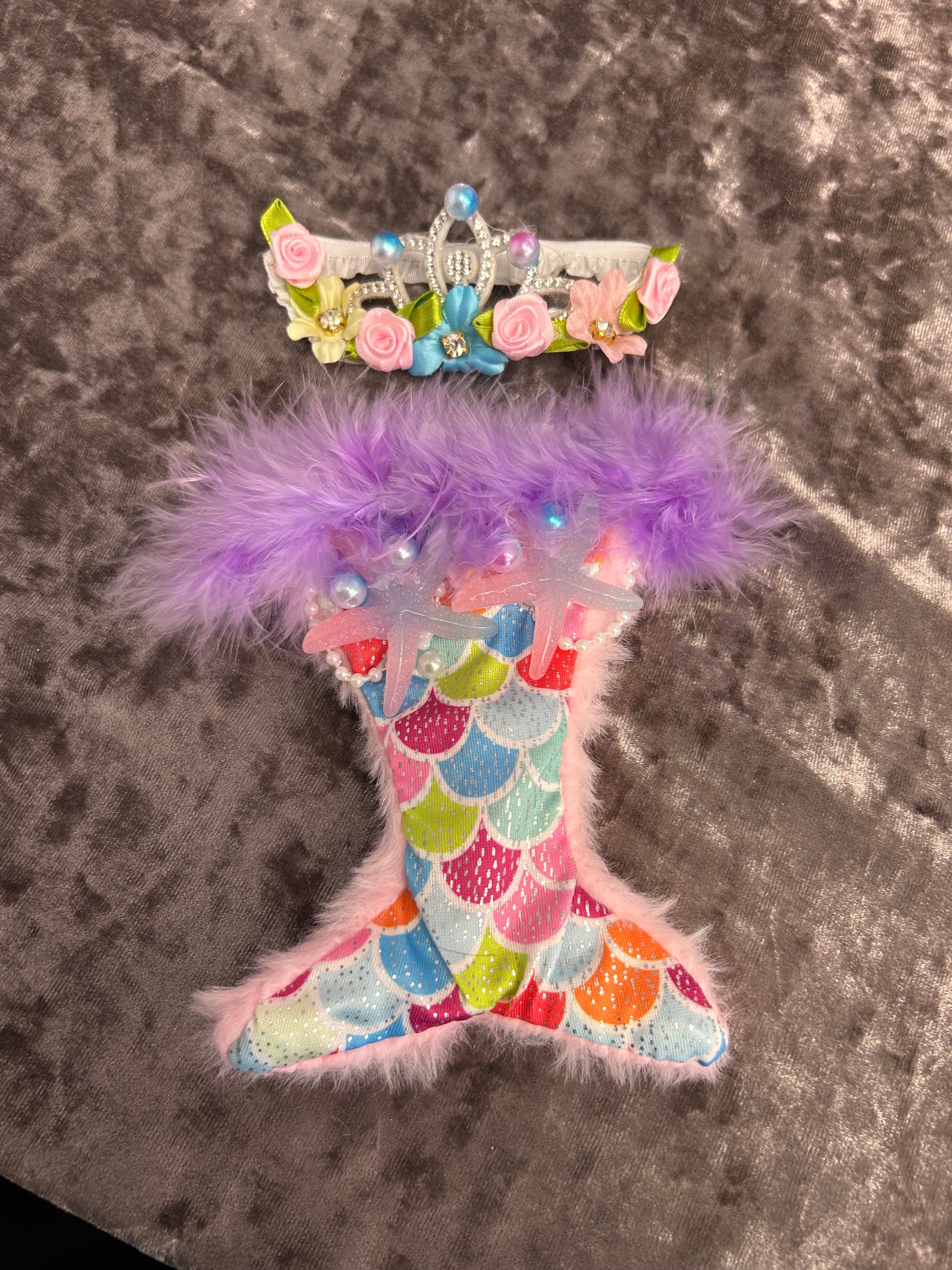Colorful fish-shaped toy with decorative elements on a textured surface