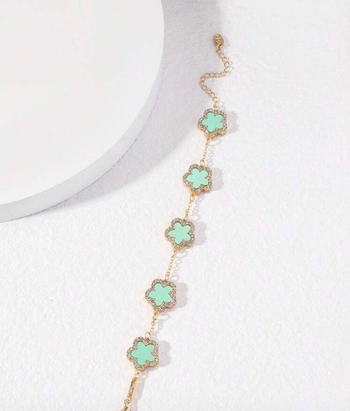     Adjustable gold bracelet with five mint clover charms and crystal detailing