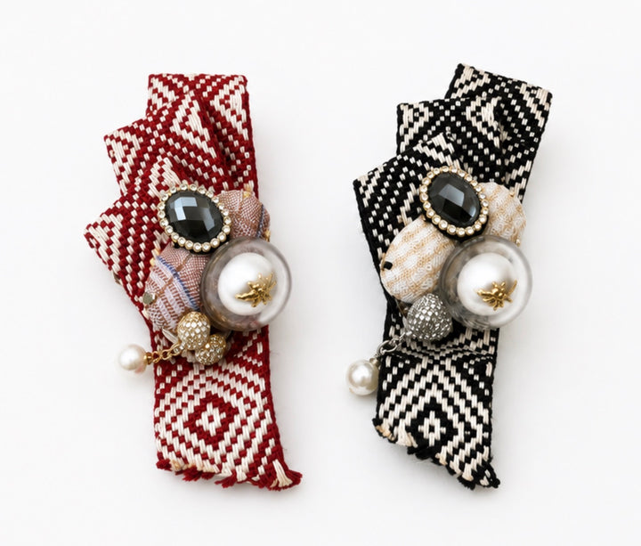 Red and black embellished fabric brooches featuring a crystal centre, faux pearl with gold bee detail and secure pin fastening