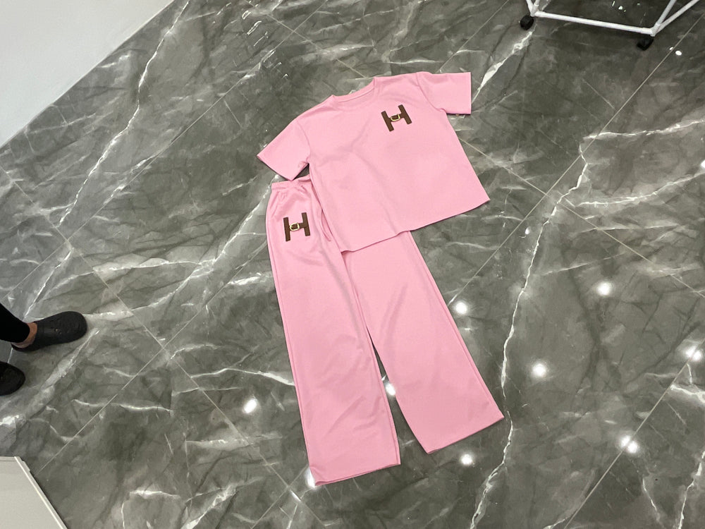 Pink set with 'H' logo on a marble floor