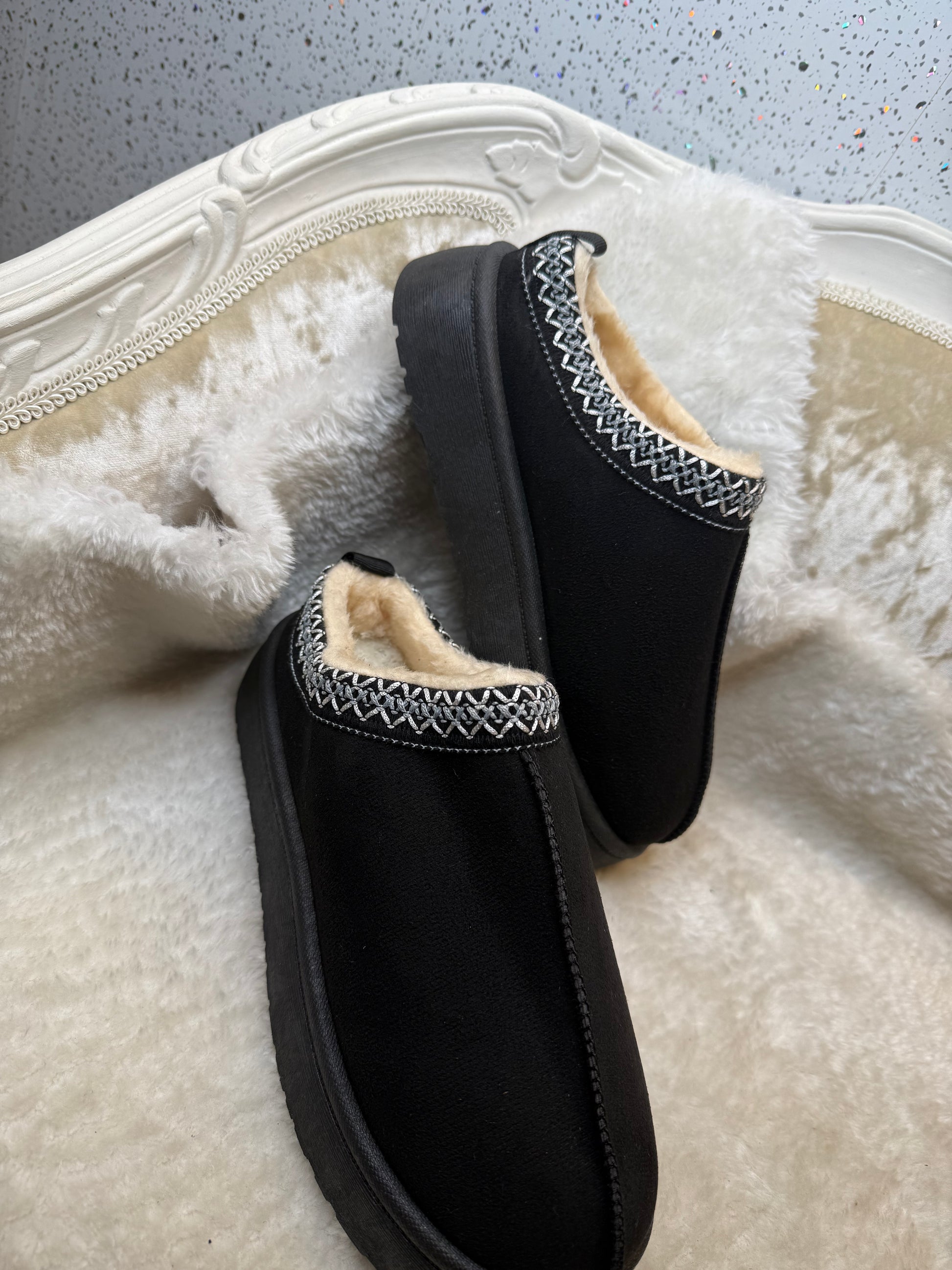 Black faux slippers with white fur lining