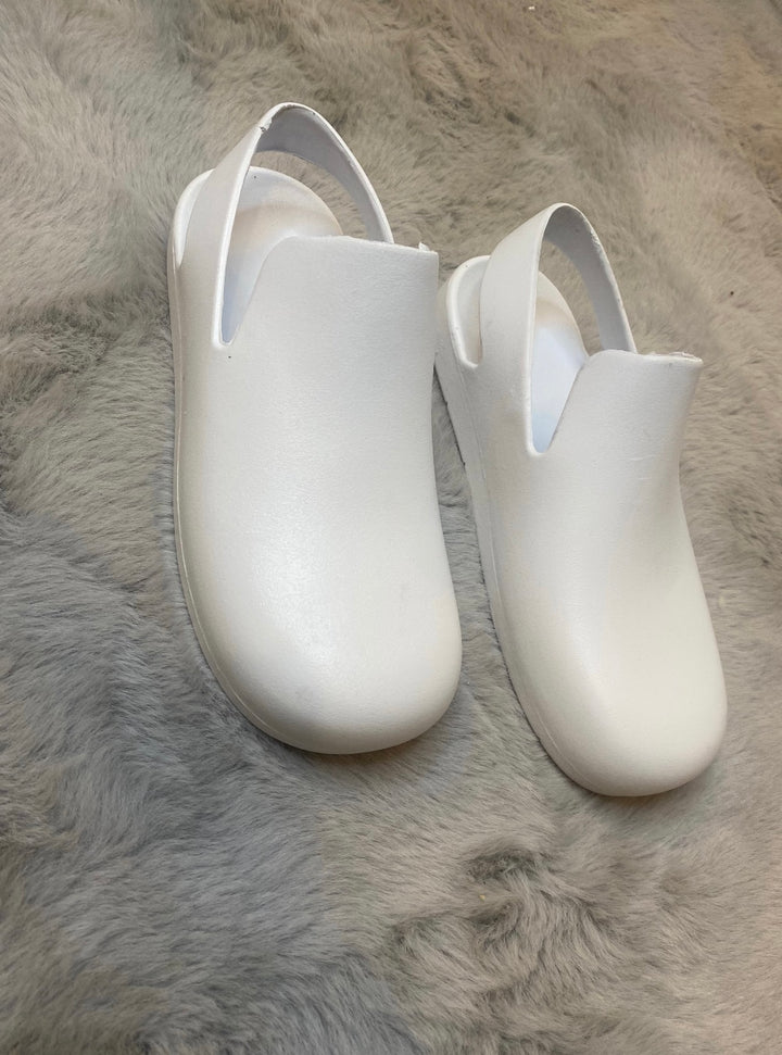 A pair of white slingback clogs 