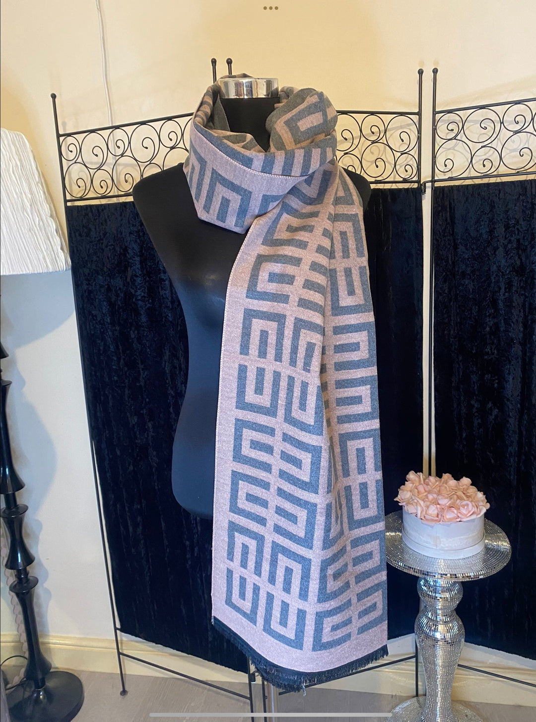 A geometric print scarf draped over a mannequin with a mix of geometric shapes in a monochrome colour palette.
