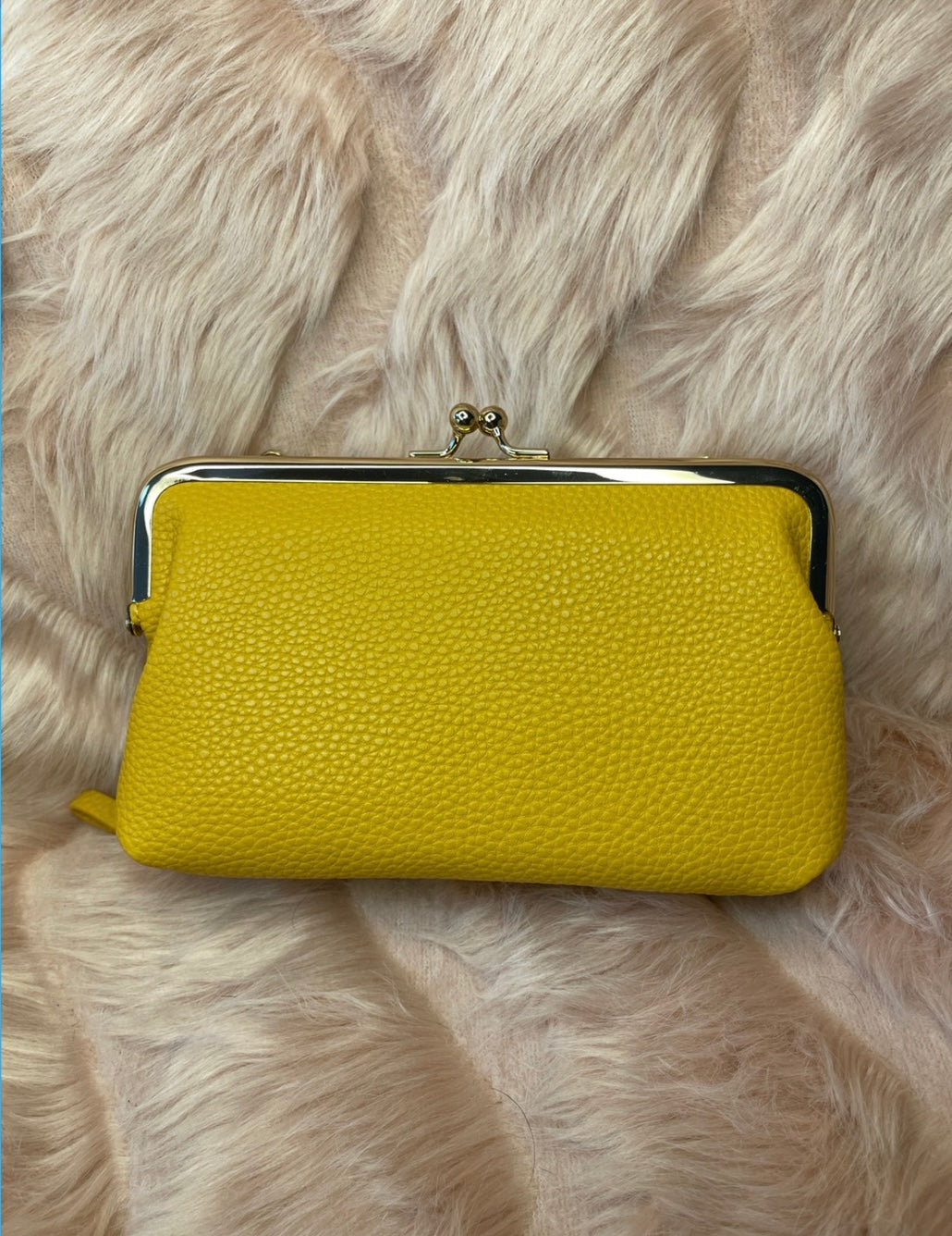 A yellow large clutch purse with silver detailing 