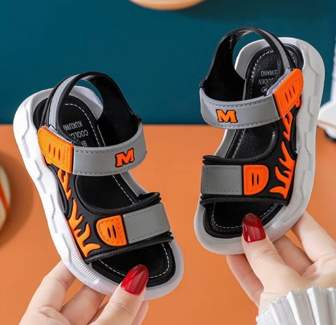 orange sandals for boys with flame detail up the sides of the sandal 