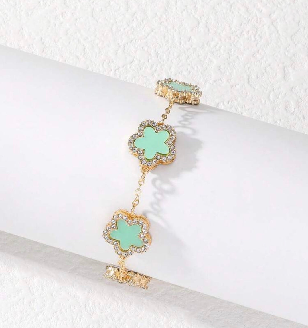     Adjustable gold bracelet with five mint clover charms and crystal detailing