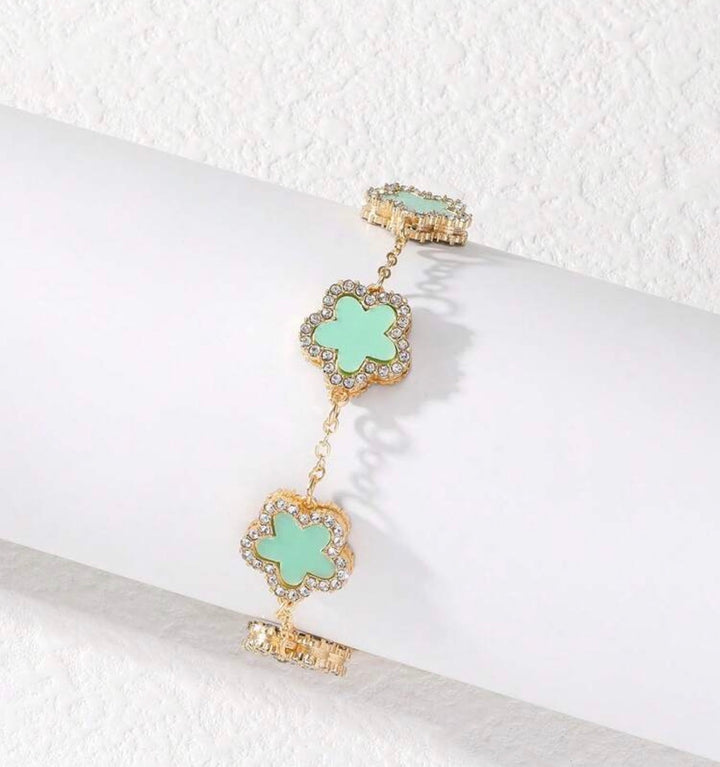     Adjustable gold bracelet with five mint clover charms and crystal detailing