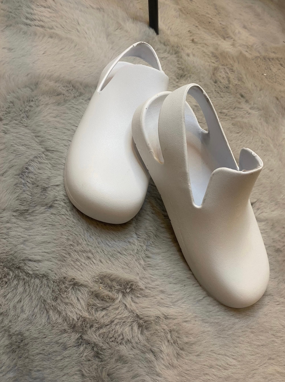 A pair of white slingback clogs 