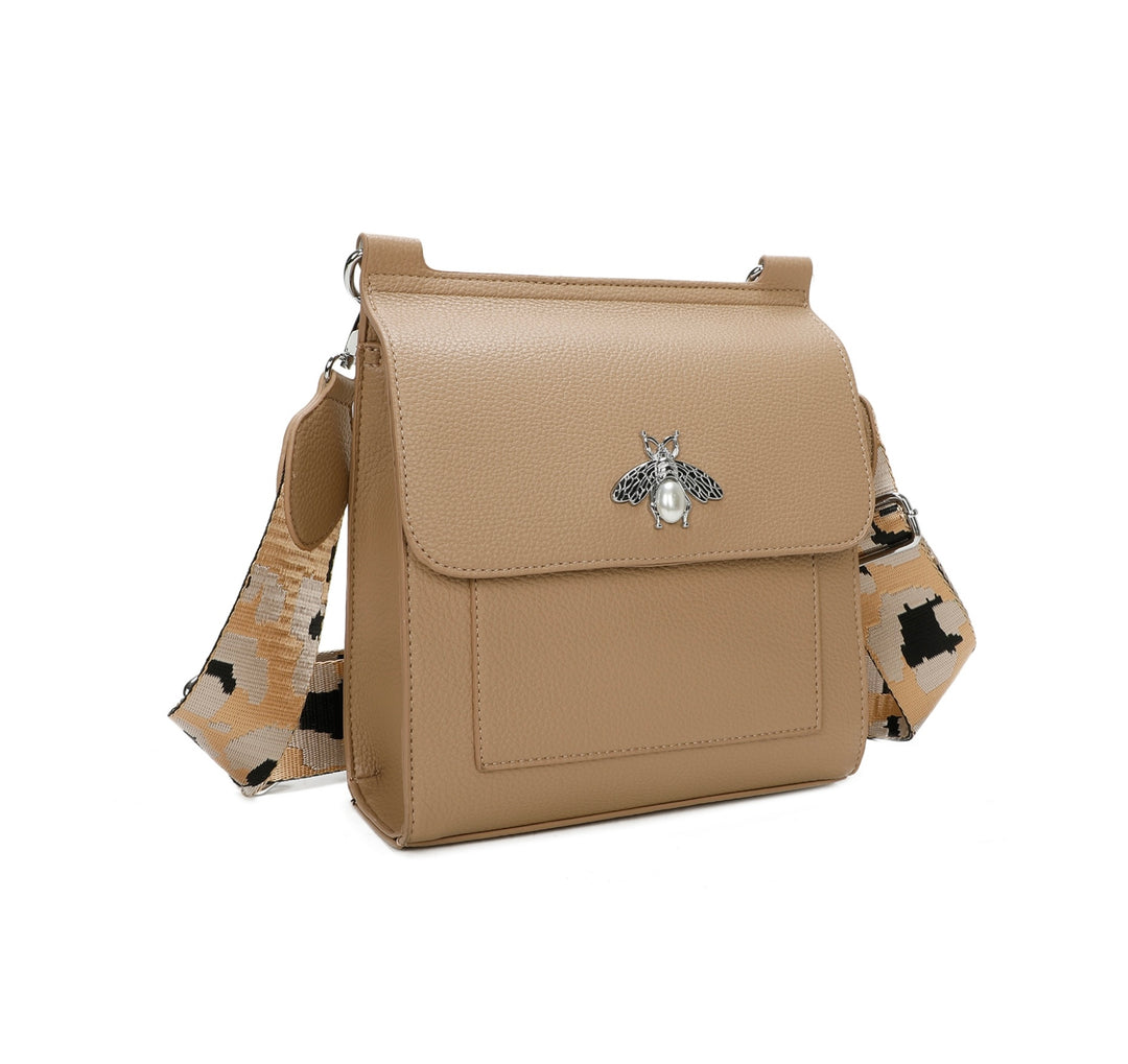 Beige crossbody bag with silver bee and pearl detail on flap, adjustable monochrome patterned straw