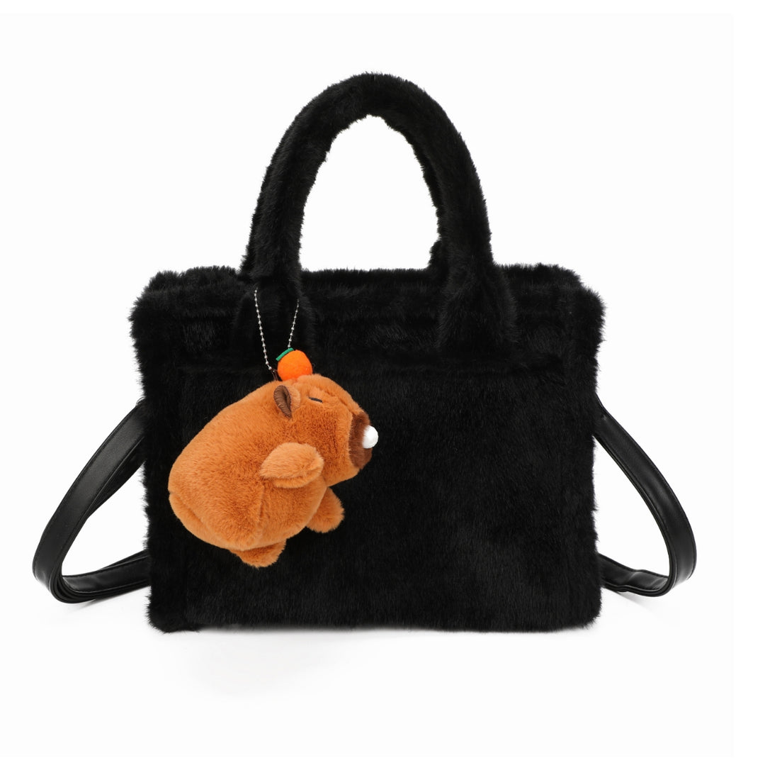Black faux-fur tote bag with a small brown teddy bear keychain and matching black handles and strap.