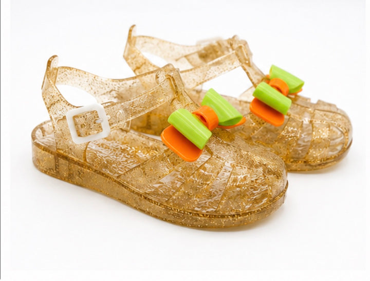 Girls colourful jelly sandals collection featuring yellow, black and glitter gold styles with decorative bows