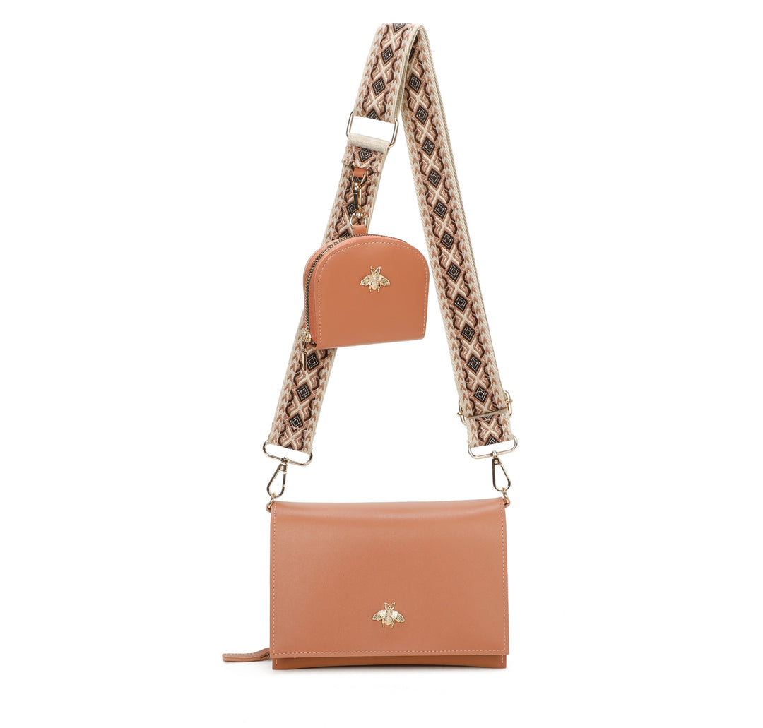 Brown leather crossbody bag with a patterned strap on a white background
