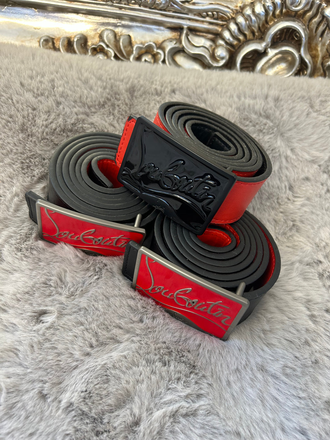 Two belts with red and black colour scheme one with black buckle