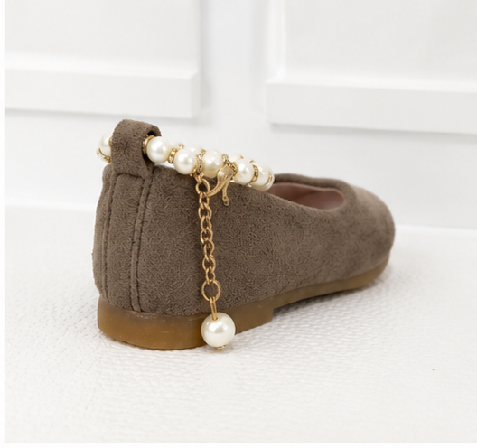 Girls taupe ballet flat shoes with pearl ankle bracelet strap, gold charm detail and soft suede-effect finish.