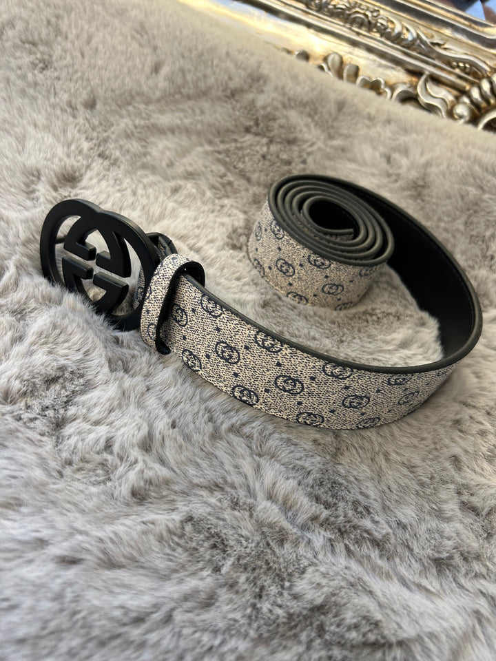 A coiled grey and black belt with a patterned buckle