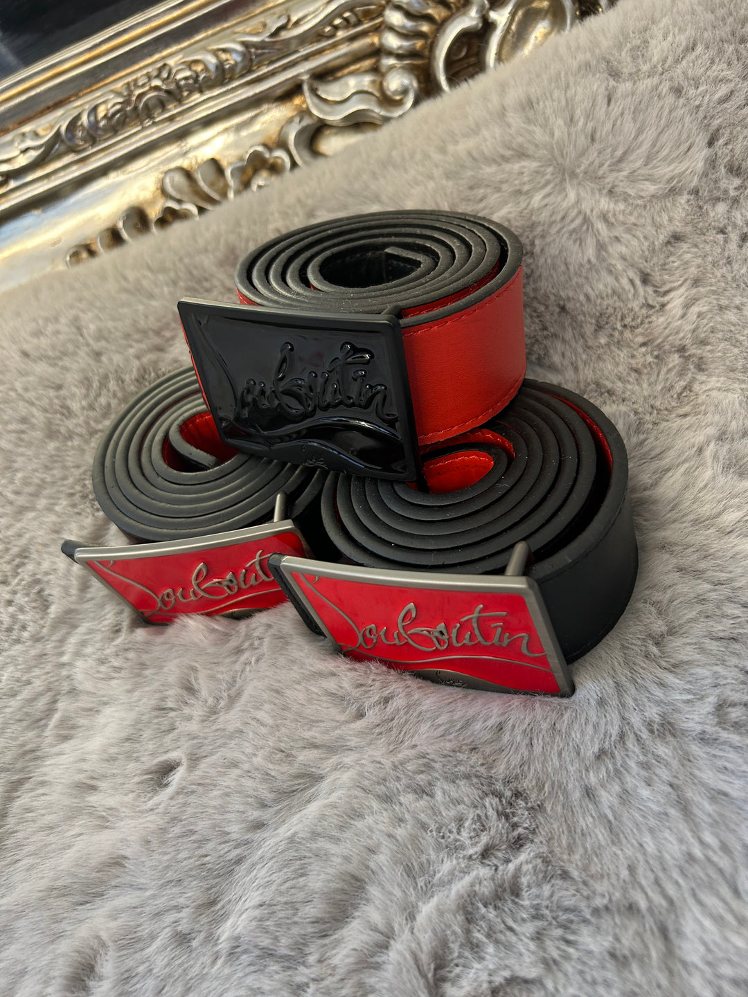 Two belts with red and black colour scheme one with black buckle