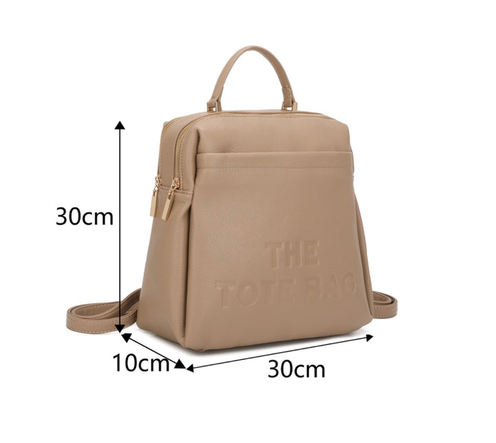 Beige rucksack with embossed “ the tote bag” writing on the front 