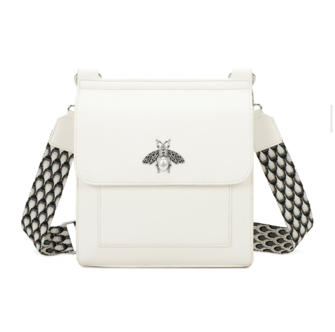 A white satchel crossbody bag with a bee design on the front flap, featuring a camouflage pattern on the strap.