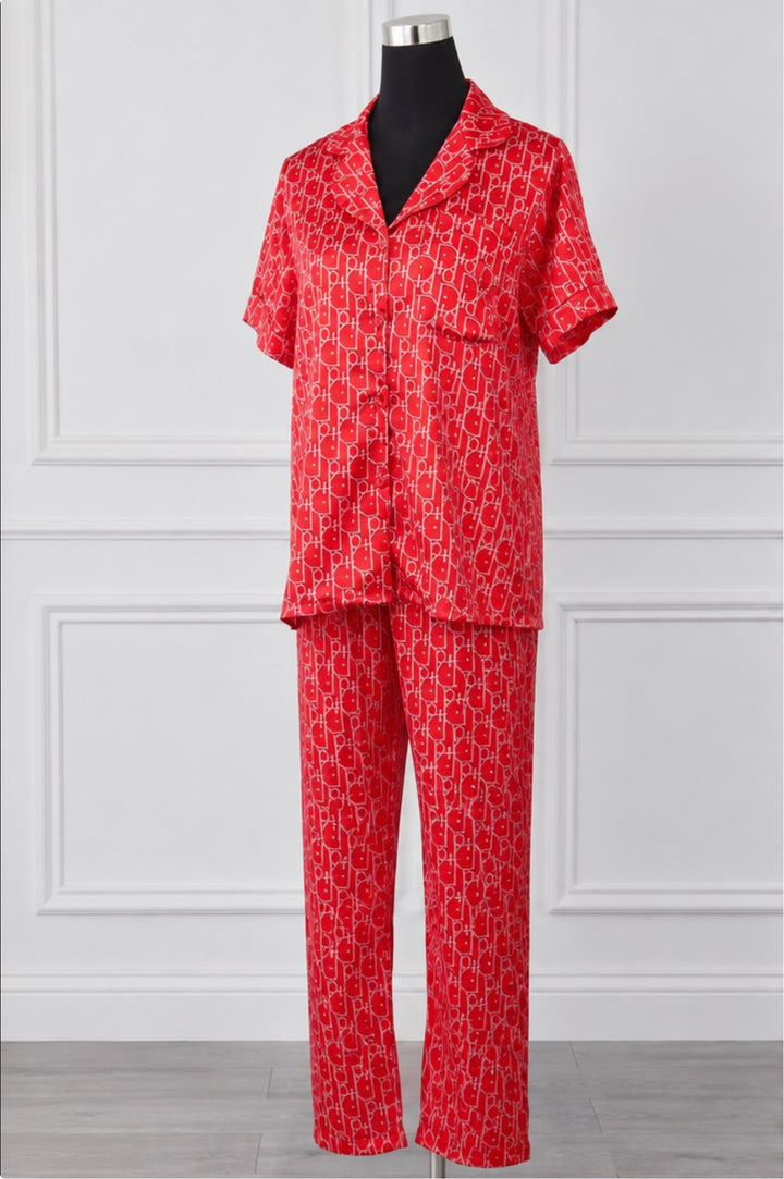 Women’s luxury red monogram satin style pyjama set with short sleeve button-up shirt and matching full-length trousers displayed on a mannequin.