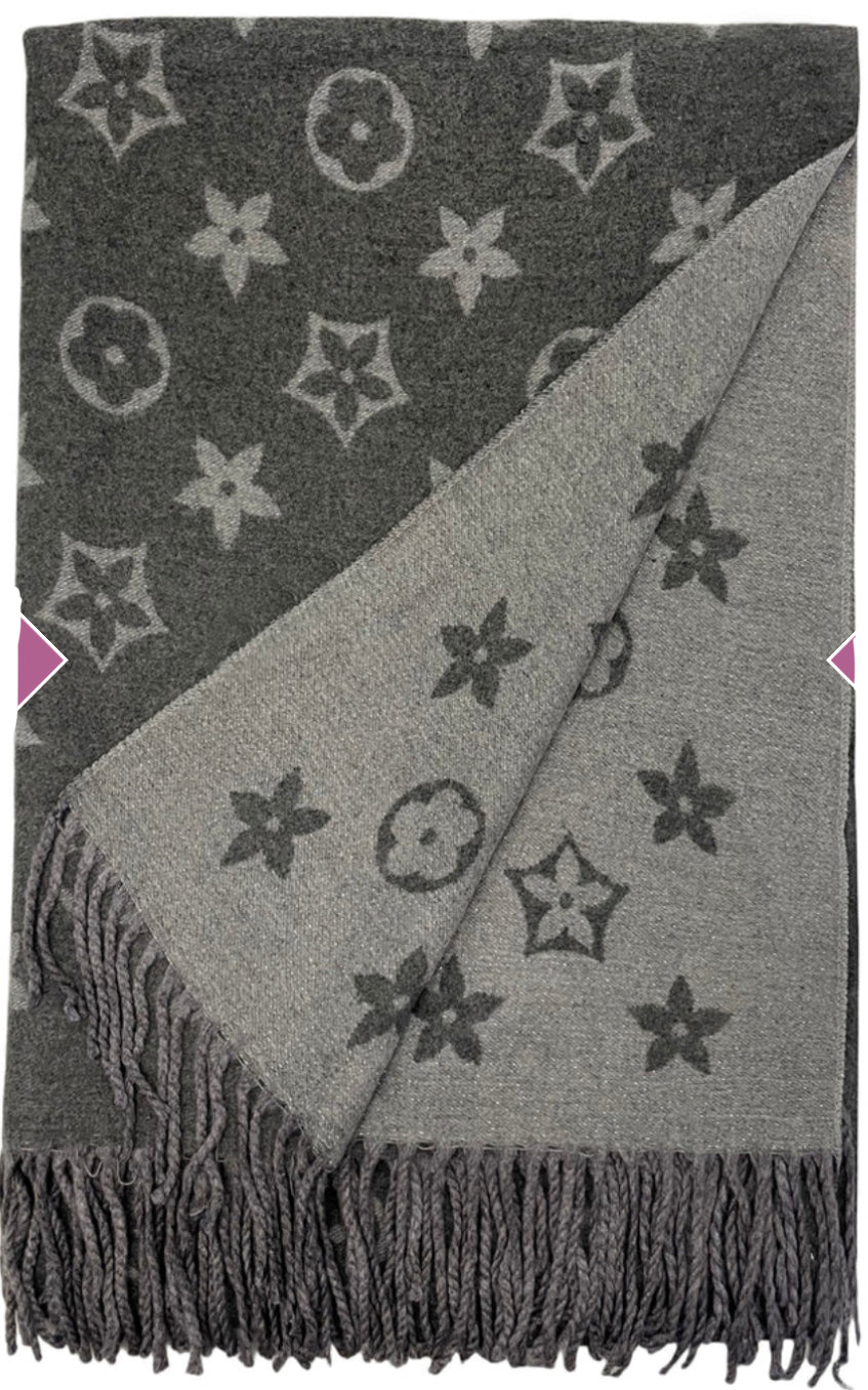 A grey scarf with sparkly metallic thread floral patterns, draped elegantly with a focus on the sparkly details.