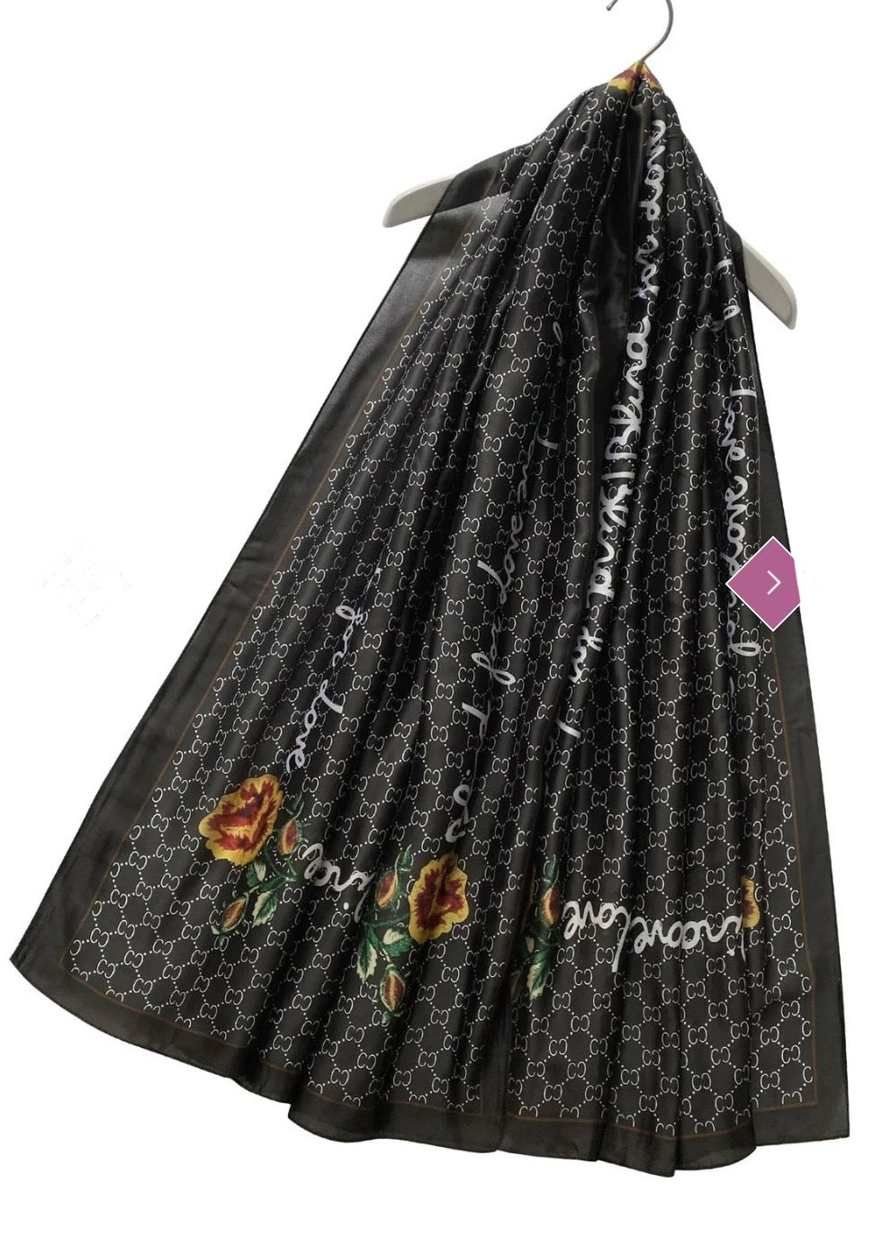 A black scarf with a geometric pattern and a multicoloured floral emblem.