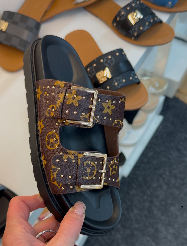Brown sliders with flower detail and a black sole 