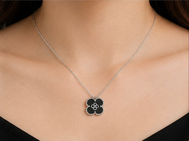 Black clover pendant necklace with silver-tone chain and detailed silver edging