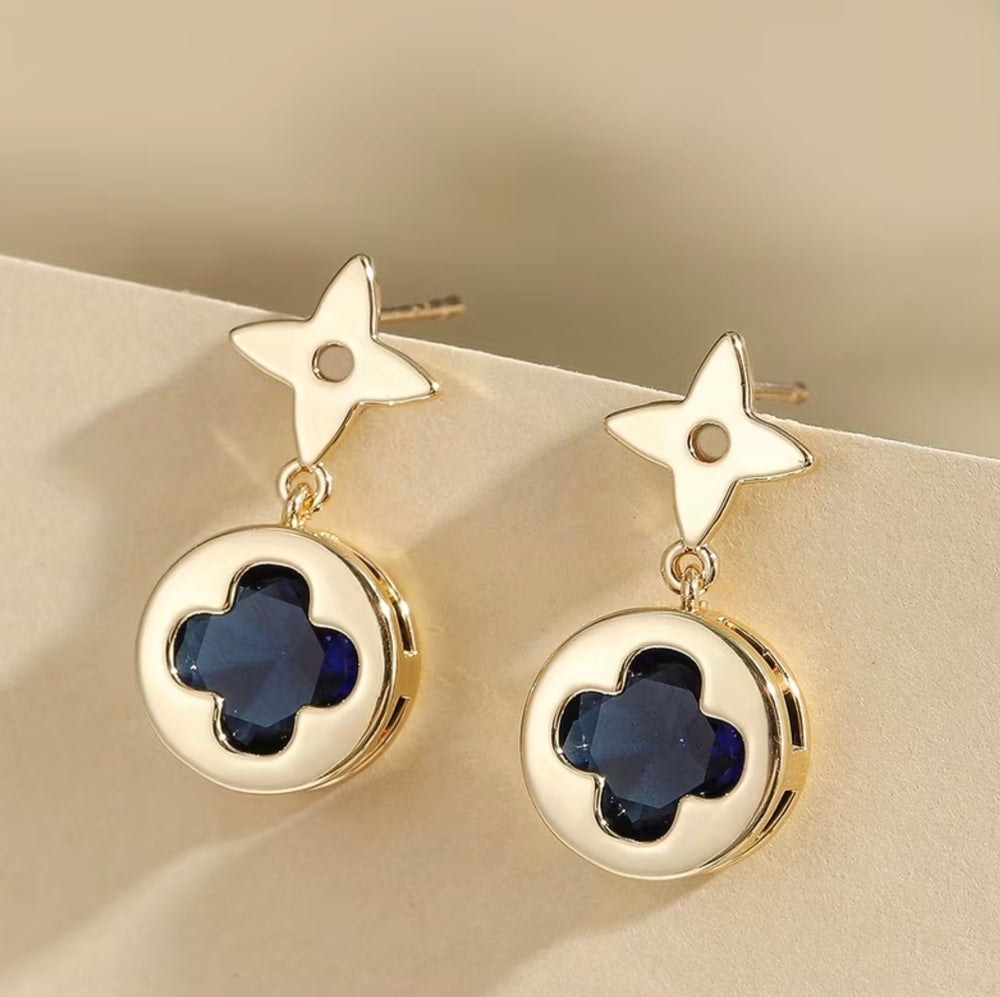     Gold clover drop earrings with deep blue crystal stone