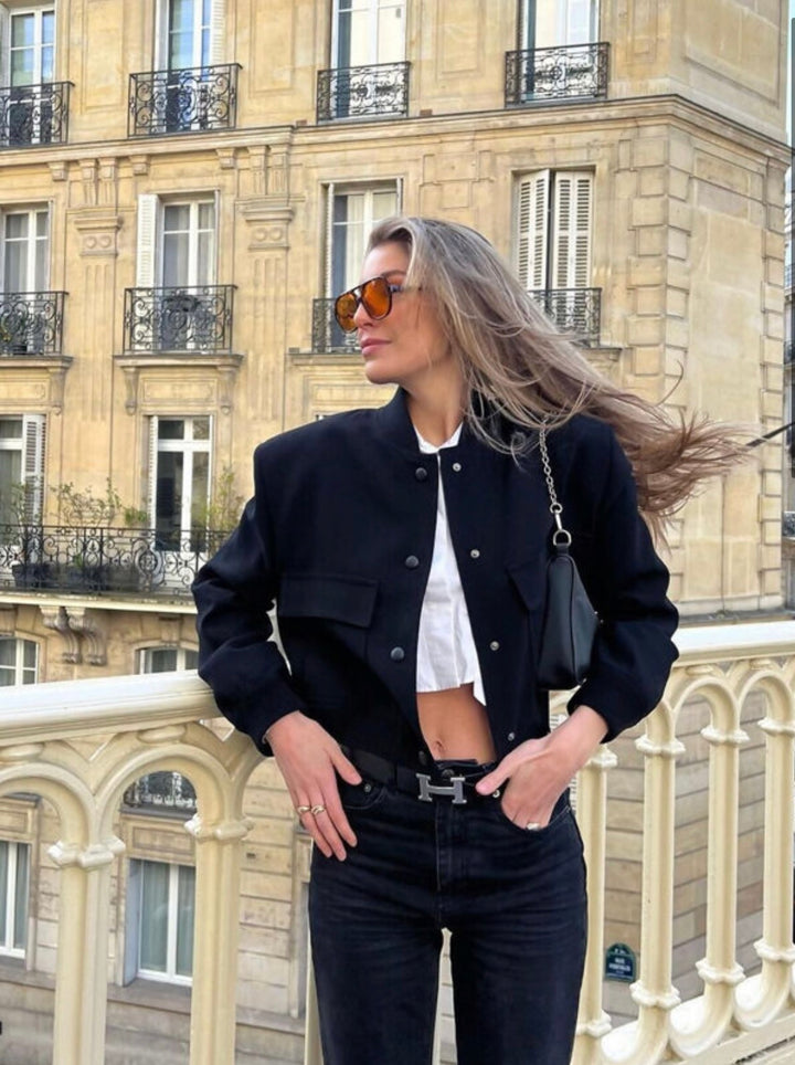 Cropped bomber jacket detail showing button fastening and pocket design