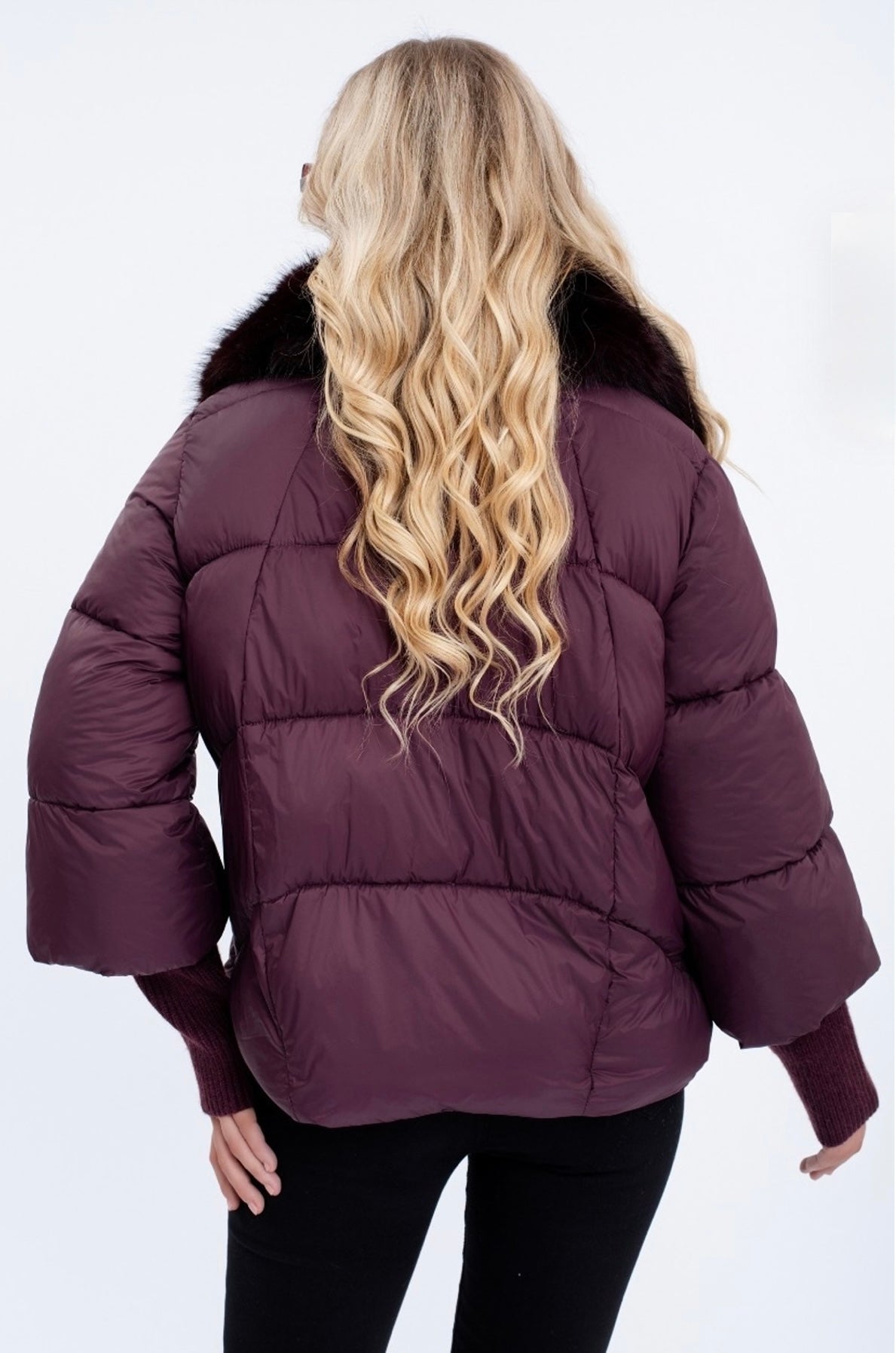 Person wearing a wine puffer jacket with fur trim