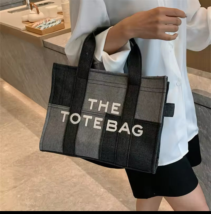 black denim patch work tote bag with bold white ‘The Tote Bag’ text
