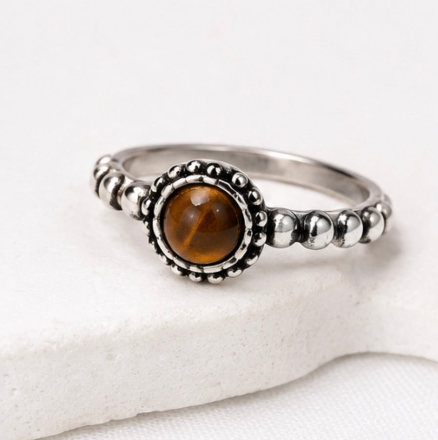 A silver ring with a round brown tiger&