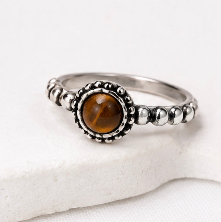 A silver ring with a round brown tiger&