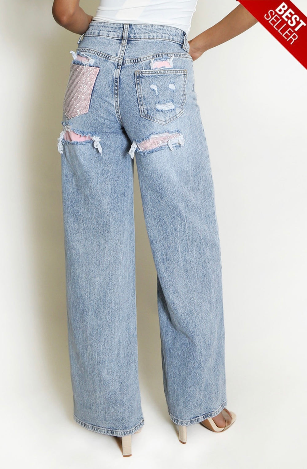     Back view of light wash wide leg jeans with pink rhinestone pocket detail
