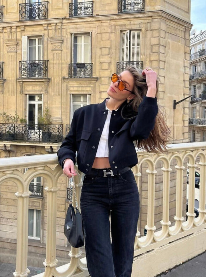 Black cropped bomber jacket styled with jeans and handbag, chic outfit
